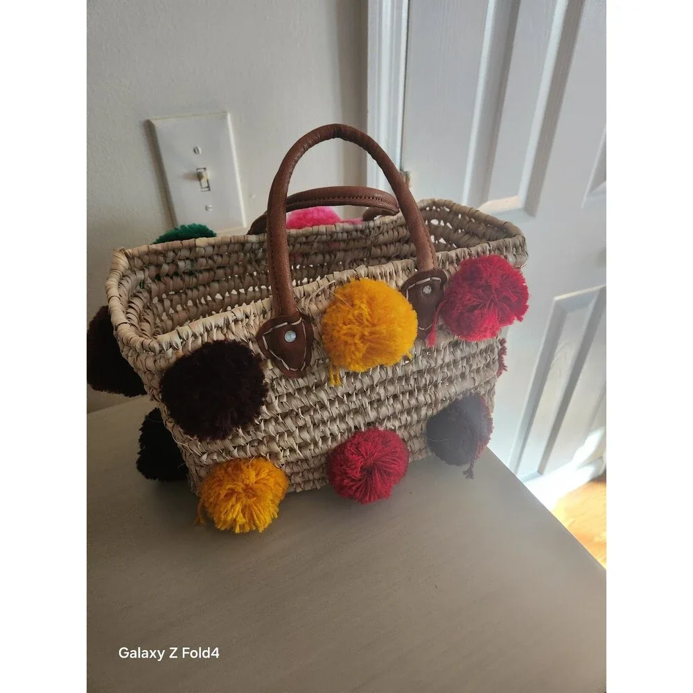 Beautiful woven straw bag with colorful pom-poms